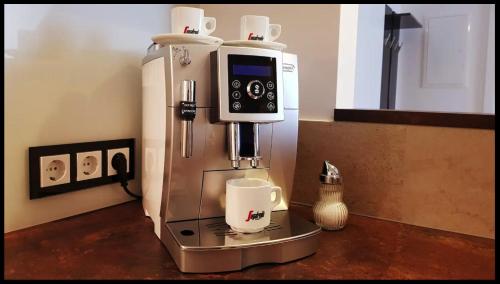 a coffee machine with a cup on top of it at Luxor City Apartments in Lienz