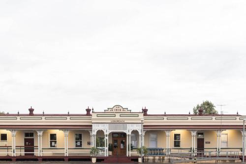 a large white building with a porch at Longreach Motor Inn in Longreach