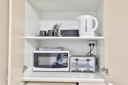 a kitchen with a microwave and a toaster oven at Boulevard Motor Inn in Mildura