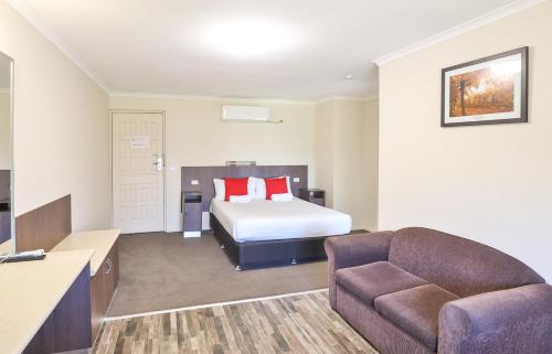 Habitación de hotel con cama y sofá en Boulevard Motor Inn, en Mildura