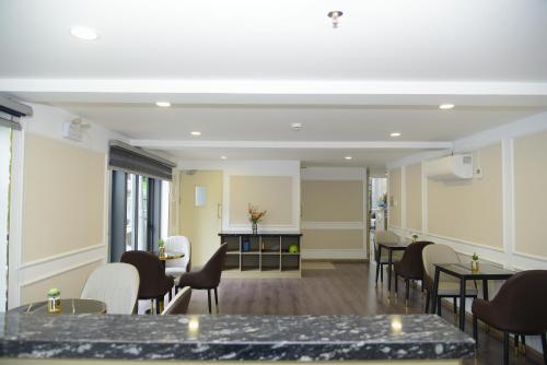 a waiting room with tables and chairs in a room at Hera Luxury Hotel in Ho Chi Minh City