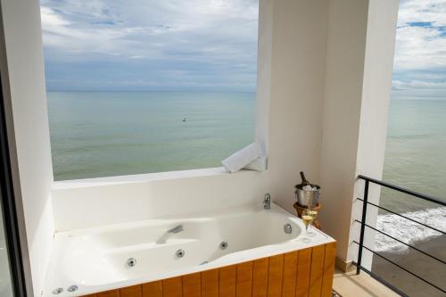 a bath tub with a view of the ocean at Jama Campay - Homes Resort & Spa in Jama