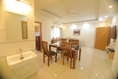 a bathroom with a sink and a table and chairs at Castle Brook Residential Homestay in Thiruvalla