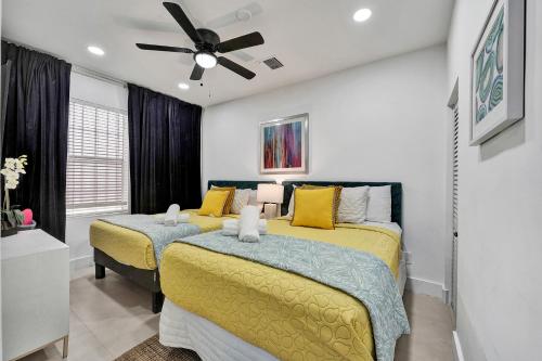 a bedroom with two beds and a ceiling fan at SOBE MONARCH 2BEDROOM 2 BATH MODERN apt- WALK TO OCEAN DRIVE in Miami Beach