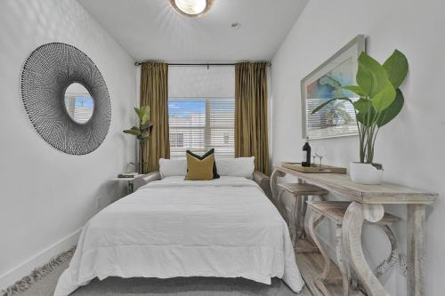 a bedroom with a bed and a table and a window at SOBE MONARCH 2BEDROOM 2 BATH MODERN apt- WALK TO OCEAN DRIVE in Miami Beach