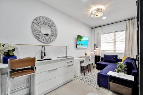 a kitchen and living room with a blue couch at SOBE MONARCH 2BEDROOM 2 BATH MODERN apt- WALK TO OCEAN DRIVE in Miami Beach