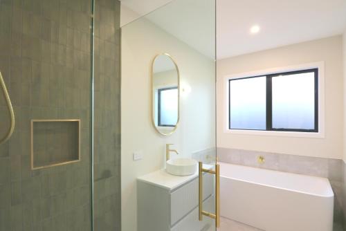 ein Bad mit einem Waschbecken und einem Spiegel in der Unterkunft The Mod Box in Invercargill