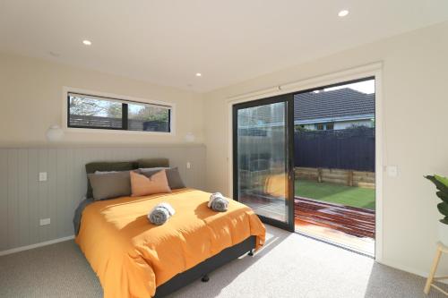 een slaapkamer met een bed en een groot raam bij The Mod Box in Invercargill