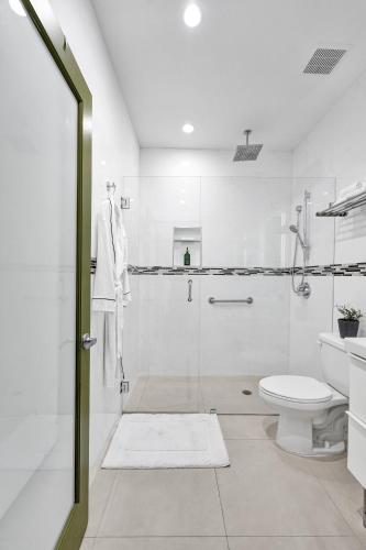 a white bathroom with a shower and a toilet at SOBE MONARCH 2BEDROOM 2 BATH MODERN apt- WALK TO OCEAN DRIVE in Miami Beach