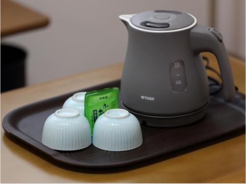 a tea kettle on a tray on a table at Pension Hinode in Hachimantai