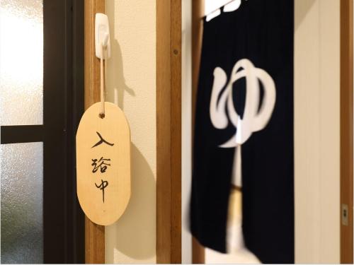 a wooden door with a sign on it at Pension Hinode in Hachimantai