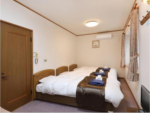 een slaapkamer met een bed met een tafel erop bij Pension Hinode in Hachimantai