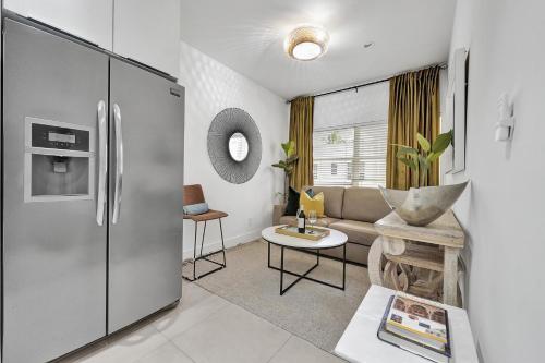 a living room with a stainless steel refrigerator at SOBE MONARCH 2BEDROOM 2 BATH MODERN apt- WALK TO OCEAN DRIVE in Miami Beach