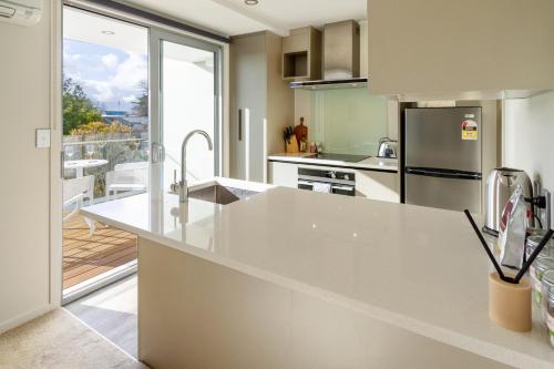 a kitchen with a large white counter top with a view at The Cozy Cocoon 1 Bed 1 Bath Apartment in Christchurch