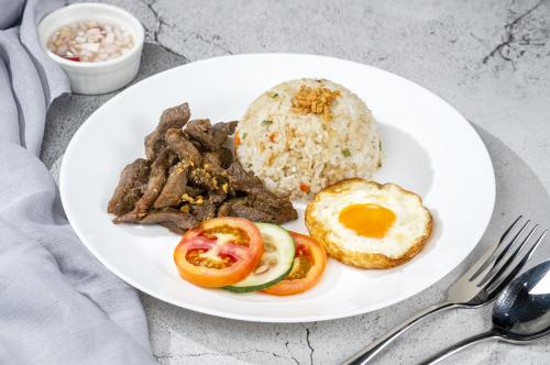 eine weiße Platte mit Eiern, Reis und Fleisch in der Unterkunft Magsaysay Hillside Resort powered by Cocotel in Magsaysay