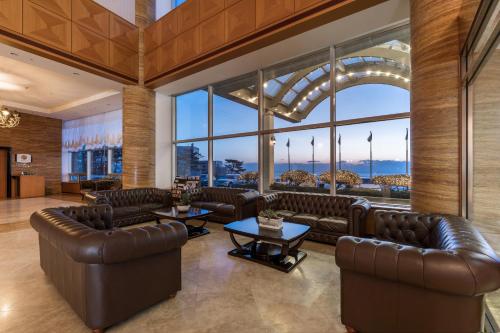 a lobby with leather furniture and large windows at Hotel Maremons in Sokcho