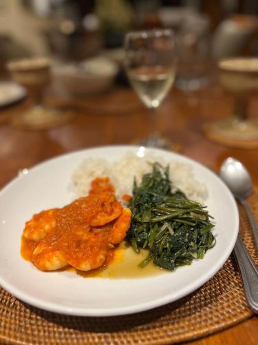 a plate of food with rice and chicken and greens at Villa Perle an Idyllic Luxury Retreat in Karangasem