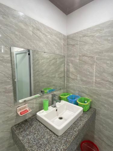 a bathroom with a white sink and a mirror at MŨM HOMESTAY MỘC CHÂU in Mộc Châu
