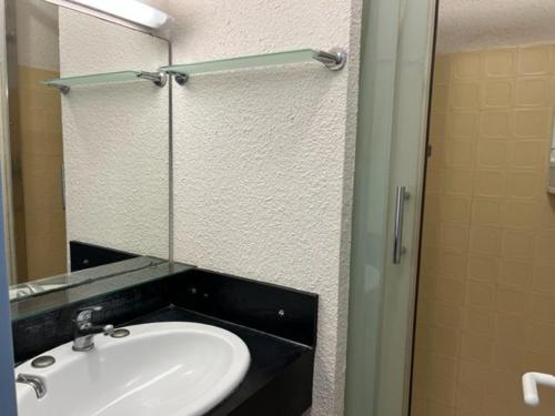 een badkamer met een wastafel en een spiegel bij Appartement Cap d'Agde, 3 pièces, 6 personnes - FR-1-749-8 in Cap d'Agde