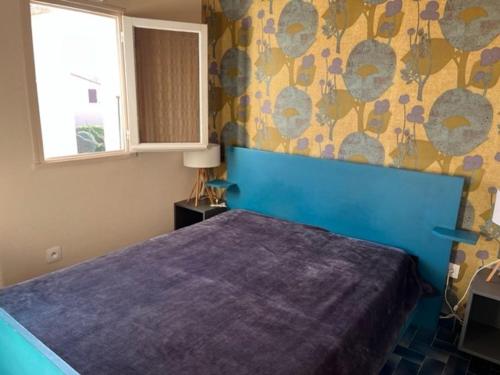 - une chambre avec un lit bleu et une tête de lit bleue dans l'établissement Appartement T3 à Cap d'Agde, 6 pers, au bord de la plage avec parking et terrasse - FR-1-749-13, au Cap d'Agde
