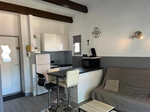 une cuisine et un salon avec un canapé et une table dans l'établissement Superbe T2 avec piscine, parking privé et terrasse, proche du village naturiste et du port - FR-1-749-17, au Cap d'Agde