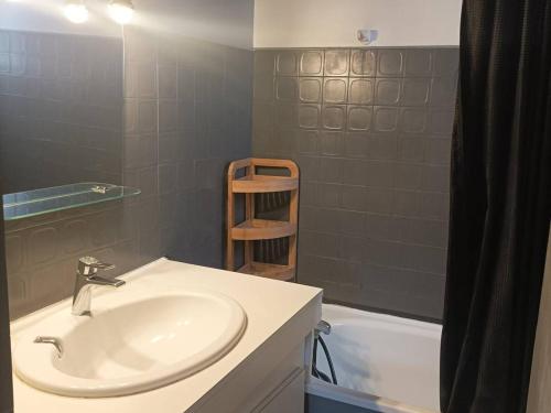 une salle de bain avec un lavabo et une baignoire dans l'établissement Superbe T2 avec piscine, parking privé et terrasse, proche du village naturiste et du port - FR-1-749-17, au Cap d'Agde