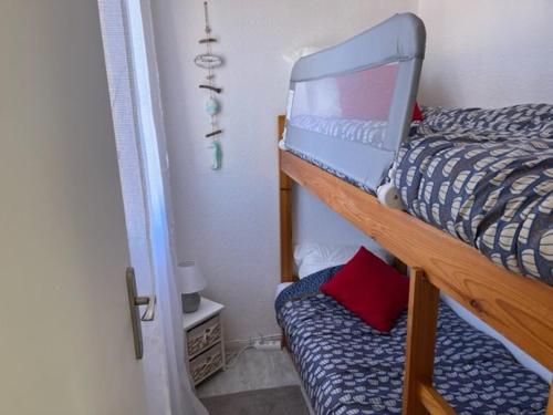 - une chambre avec des lits superposés et un ordinateur portable dans l'établissement Appartement Rénové avec Clim, Parking, Piscine—Proche Commerces, Plage et Port au Cap d'Agde - FR-1-749-6, au Cap d'Agde