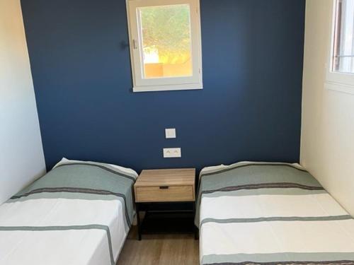 2 Betten in einem Zimmer mit blauer Wand in der Unterkunft Appartement Cap d'Agde, 3 pièces, 4 personnes - FR-1-749-11 in Cap d'Agde