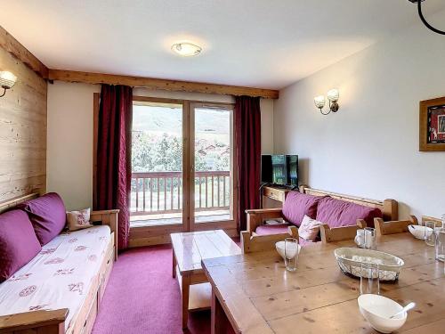 ein Wohnzimmer mit lilafarbenen Möbeln und einem großen Fenster in der Unterkunft Appartement La Toussuire, 3 pièces, 6 personnes - FR-1-267-272 in La Toussuire