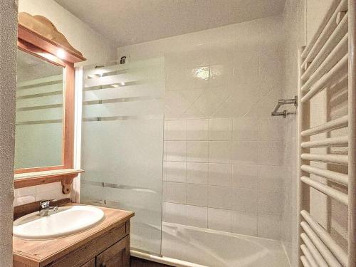 une salle de bain blanche avec un lavabo et une douche dans l'établissement Appartement cosy avec balcon, parking, piscine et navette à 150m du centre et 500m des pistes - FR-1-267-272, à La Toussuire