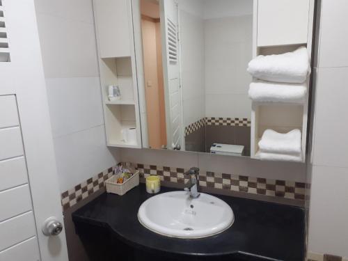 a bathroom with a sink and a mirror and towels at simple 14 nha chung in Hanoi