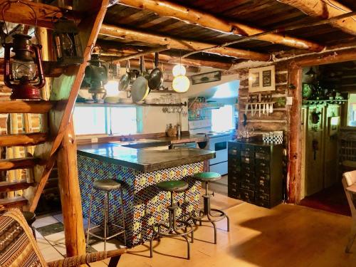 - une cuisine avec un comptoir et des tabourets dans une pièce dans l'établissement Chalet en bois rond Mauricie, à Saint-Alexis-des-Monts