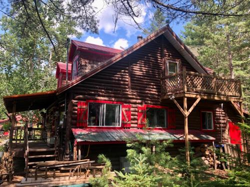 a log cabin in the woods with a deck at Chalet en bois rond Mauricie in Saint-Alexis-des-Monts