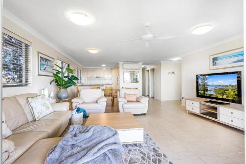 a living room with a couch and a tv at Salty Kisses @ Riverdance - 3 bedroom apartment in Mooloolaba