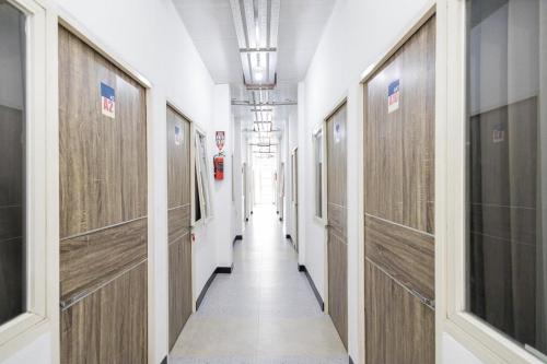 a hallway with wooden doors in a building at RedDoorz @ Tanjung Sari Surabaya in Tandjung-lor