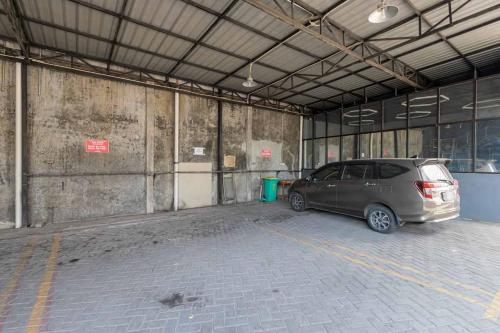a car parked in a parking lot in a building at RedDoorz @ Tanjung Sari Surabaya in Tandjung-lor