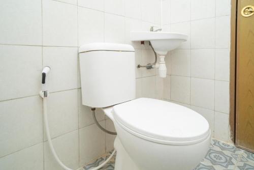 a bathroom with a white toilet and a sink at RedDoorz @ Tanjung Sari Surabaya in Tandjung-lor