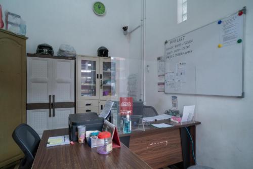 a room with a table and a white wall at RedDoorz @ Tanjung Sari Surabaya in Tandjung-lor