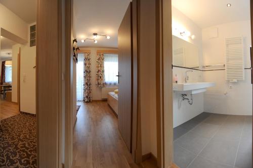 a kitchen and living room with a sink and a mirror at Carinthia in Weissensee