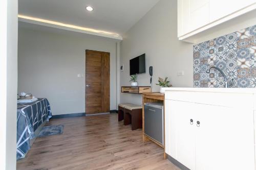 a kitchen and living room with a bed and a desk at Midway Stay Apartments Dumaguete in Dumaguete