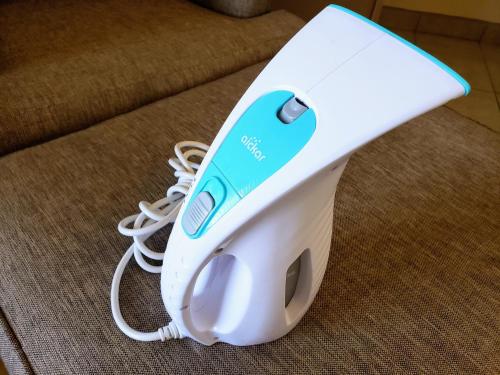 a white electric hair dryer sitting on a couch at White Sands Retreat in Alamogordo