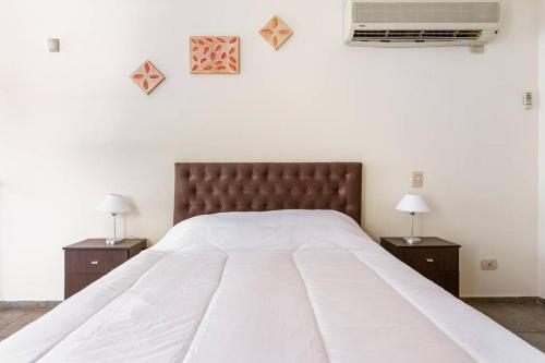 a bedroom with a large bed with two night stands at Escápate a Mendoza !! Apartamento SAN MARTIN in Godoy Cruz