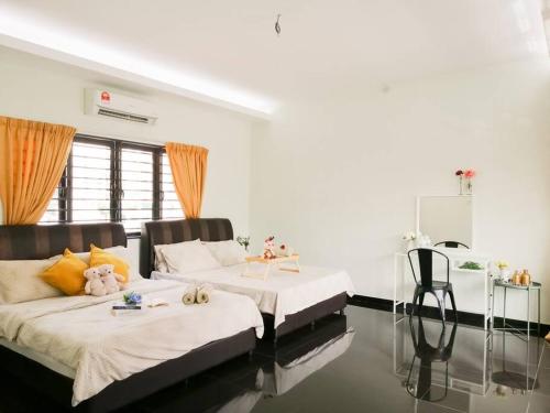 1 dormitorio con 2 camas y mesa. en The 29 Bungalow Setapak KL by Manhattan Group, en Kuala Lumpur