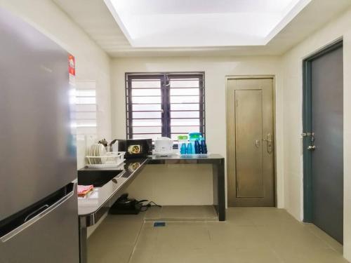 a kitchen with a desk and a window in a room at The 29 Bungalow Setapak KL by Manhattan Group in Kuala Lumpur