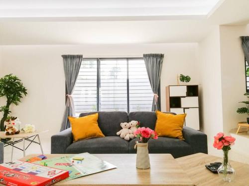 a living room with a couch with yellow pillows and a table at The 29 Bungalow Setapak KL by Manhattan Group in Kuala Lumpur