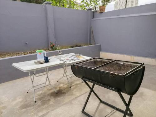a barbecue grill sitting on top of a white table at The 29 Bungalow Setapak KL by Manhattan Group in Kuala Lumpur