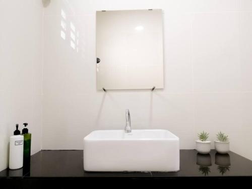 a white bathroom with a sink and a mirror at The 29 Bungalow Setapak KL by Manhattan Group in Kuala Lumpur