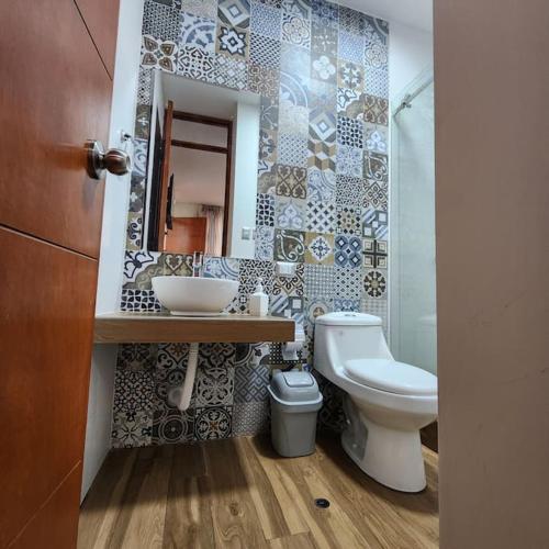 a bathroom with a sink and a toilet and a mirror at La casa de Teo in Ica