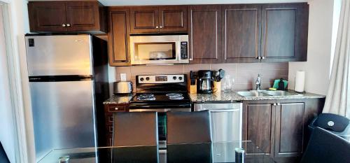 a kitchen with wooden cabinets and stainless steel appliances at Lakefront living Downtown Toronto - Free Parking, Gym, Indoor Pool in Toronto