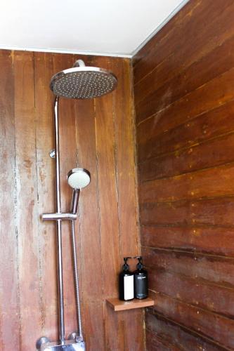 a shower in a room with a wooden wall at Natuna Dive Resort in Ranai